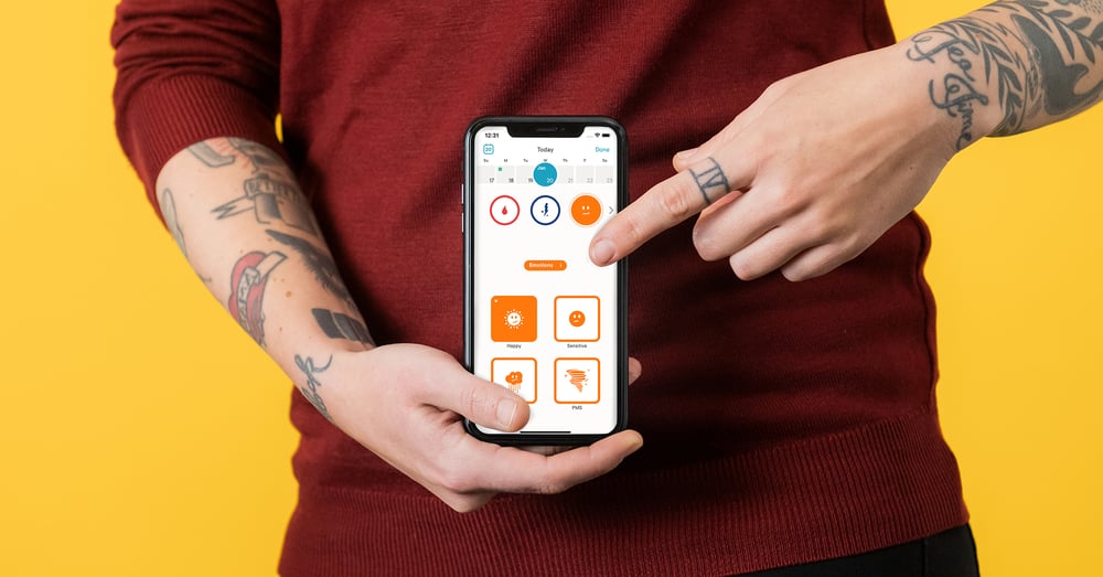A person pointing to the period tracking feature on the Clue app.