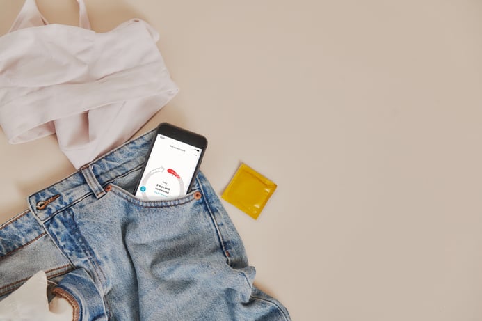 The Clue app on a phone that’s sticking out of the pocket of a pair of jeans. 